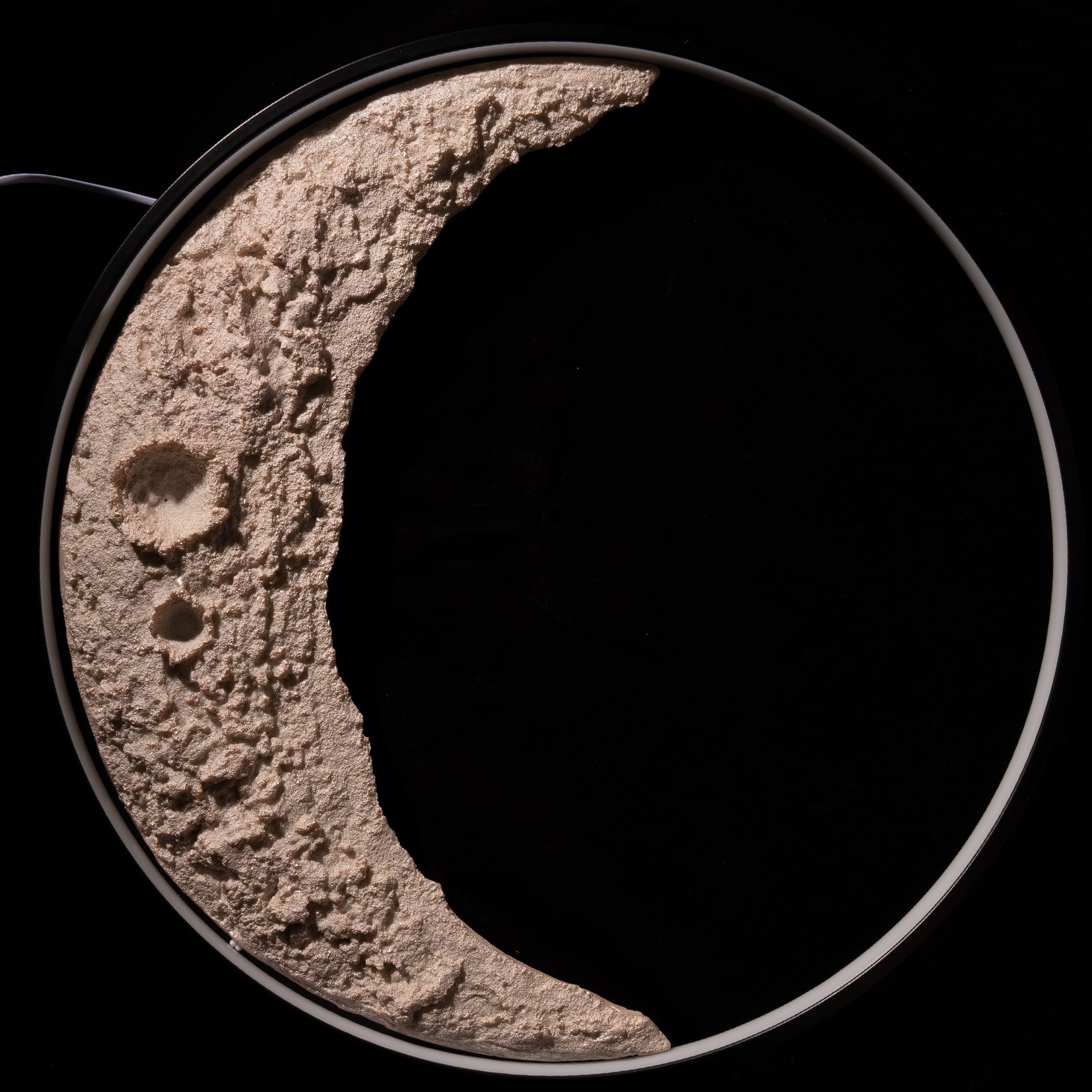 Textured crescent moon shape on a black background