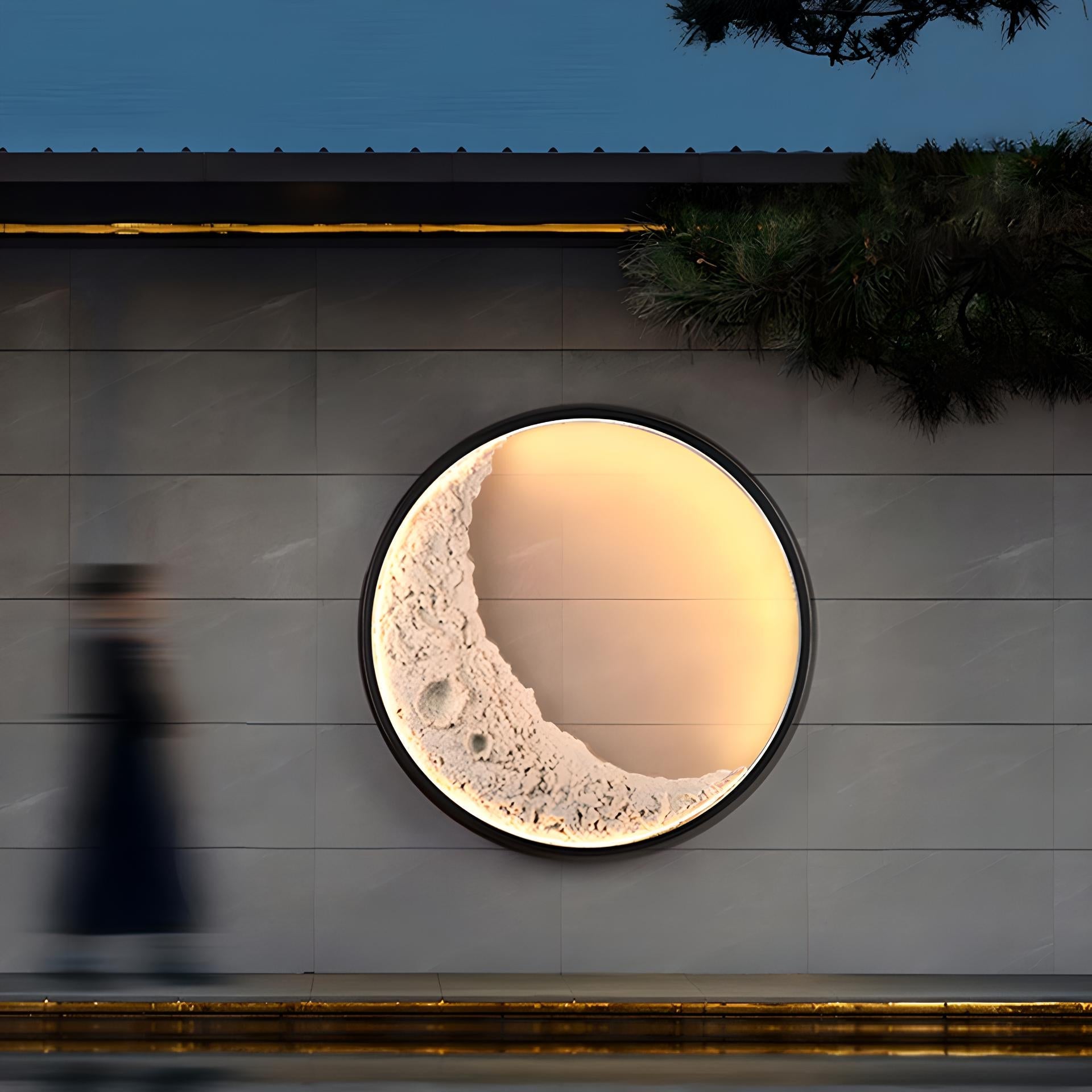 Round moon-shaped wall light on a wooden wall at night