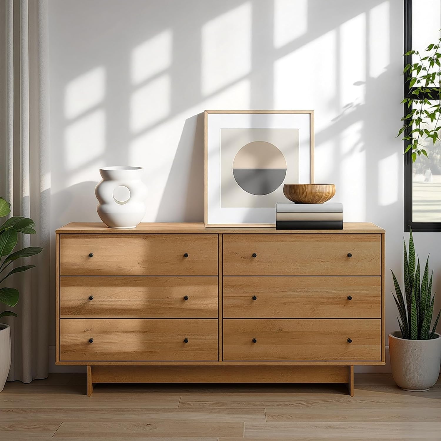 Wooden dresser with decorative items in a bright room with sunlight filtering through.
