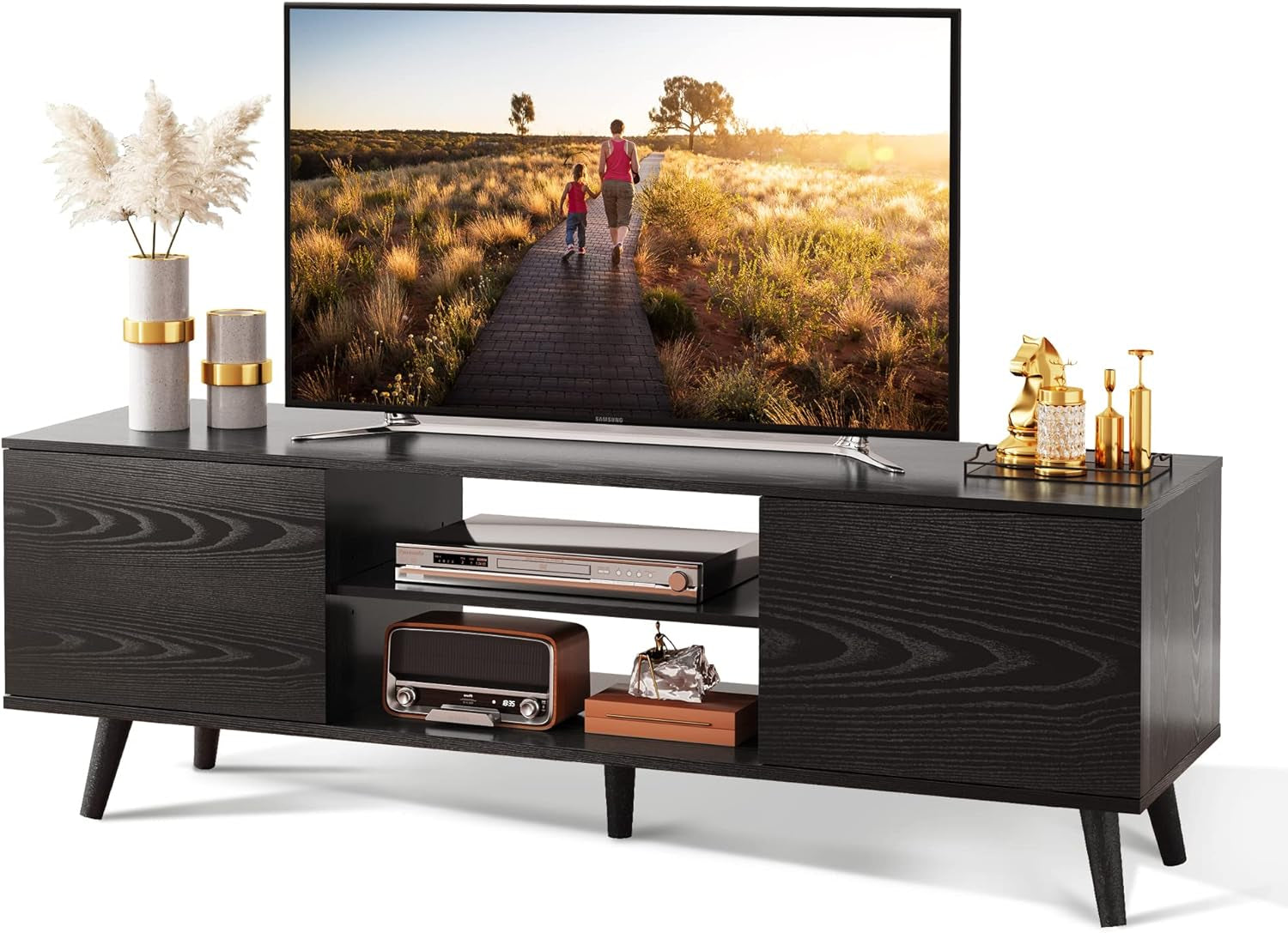 Black TV stand with a television displaying a scenic view, decorated with plants and small items.