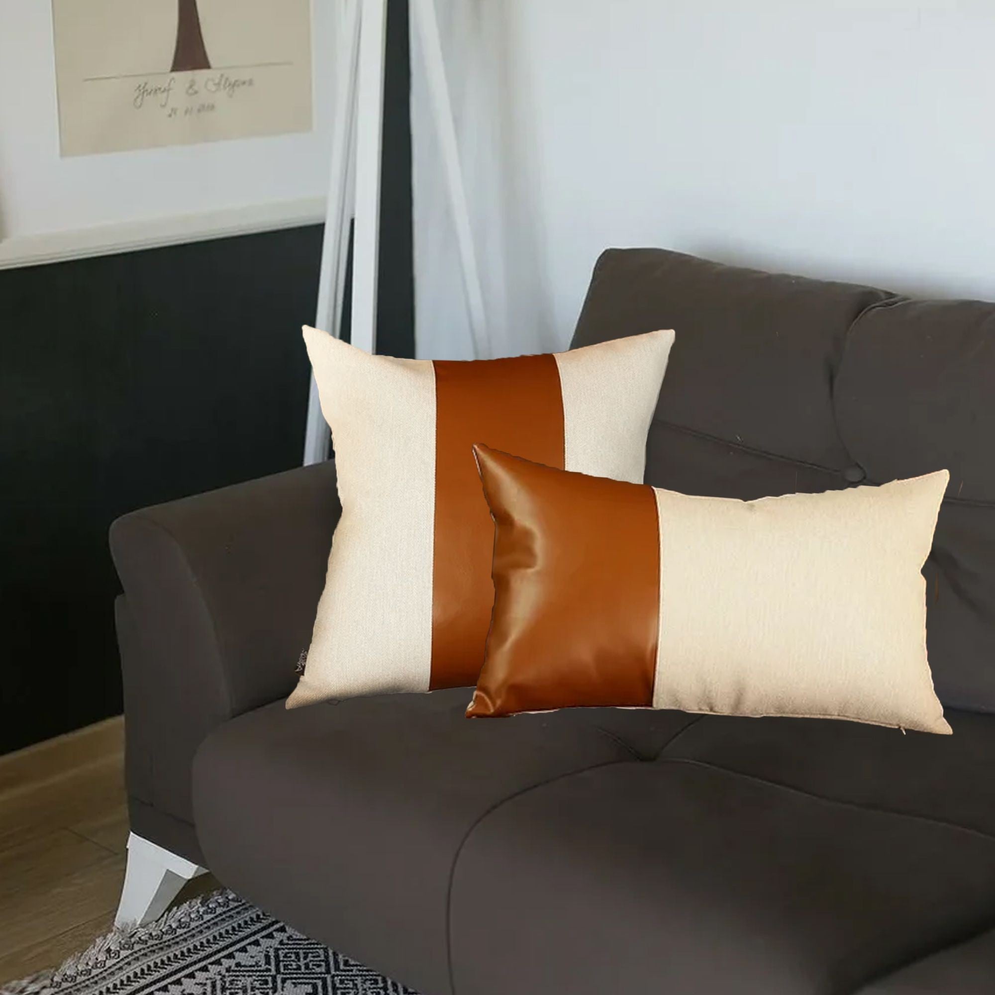 Two decorative pillows with brown and beige color block design on a dark sofa.