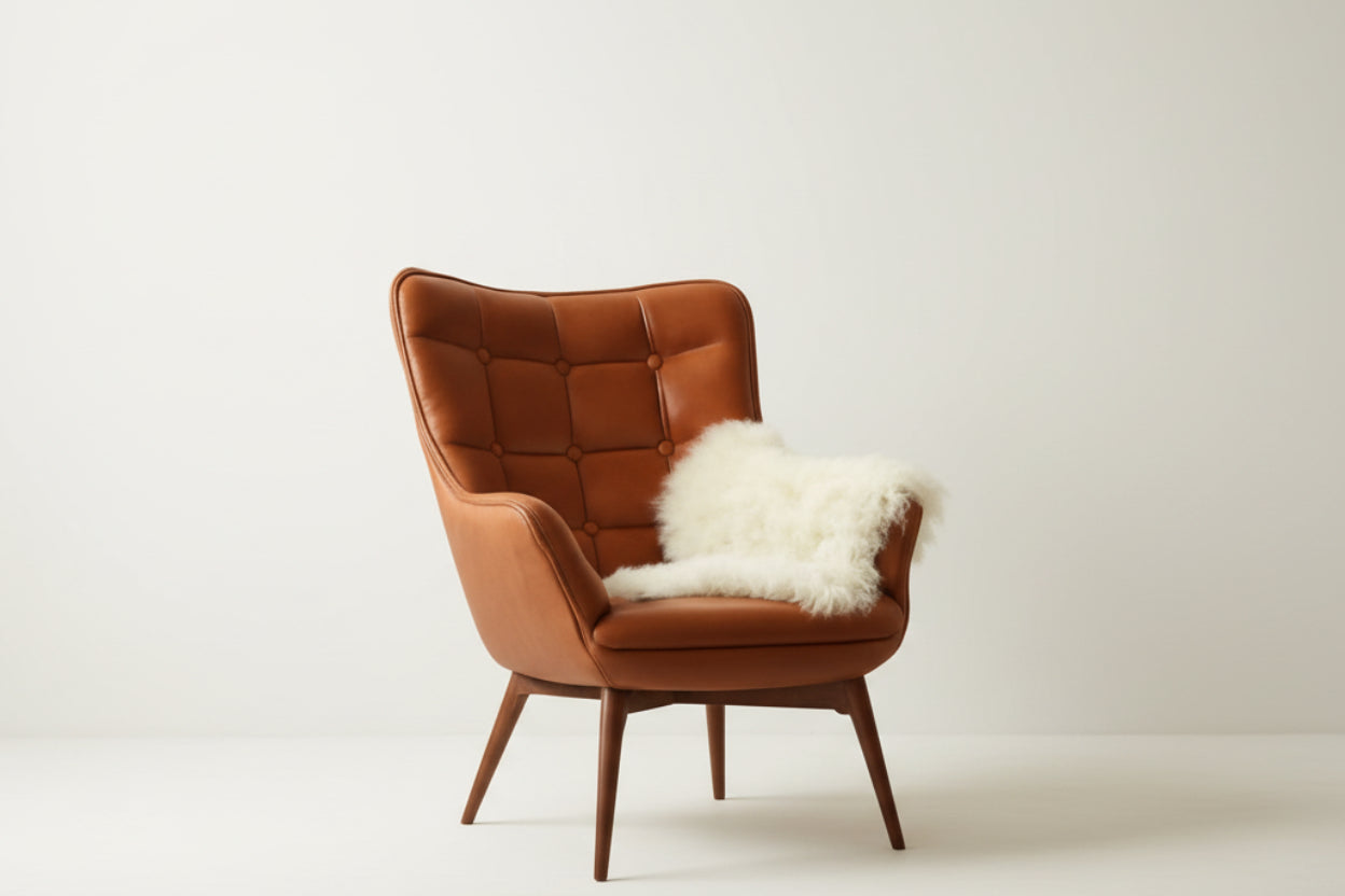 Brown leather armchair with a white fur throw on a white background