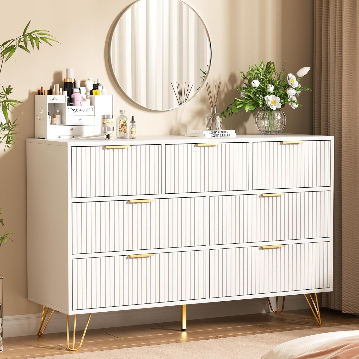 White dresser with gold legs in a room setting with a mirror and decorative items.