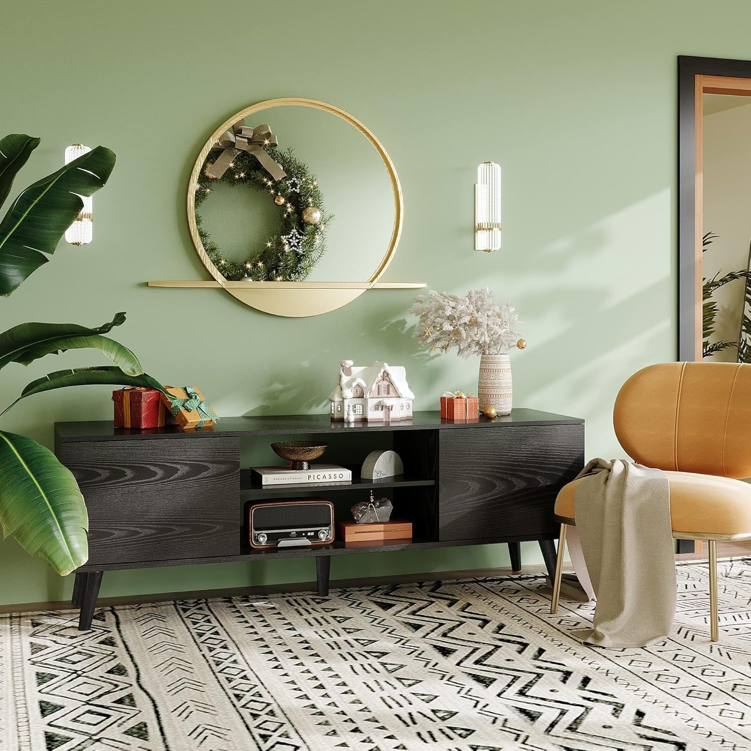 Modern living room with a green wall, decorative wreath, and a wooden console table.