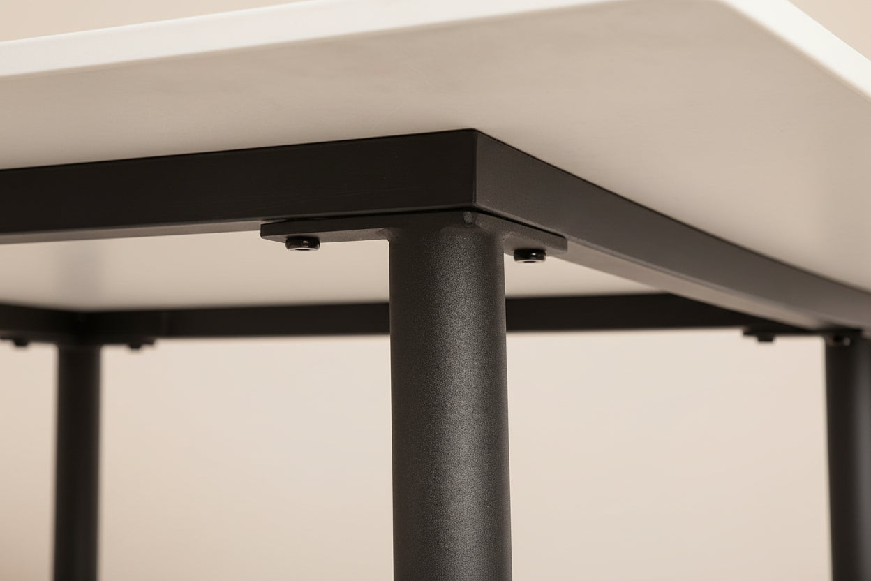 Close-up of a black metal table leg with a white surface