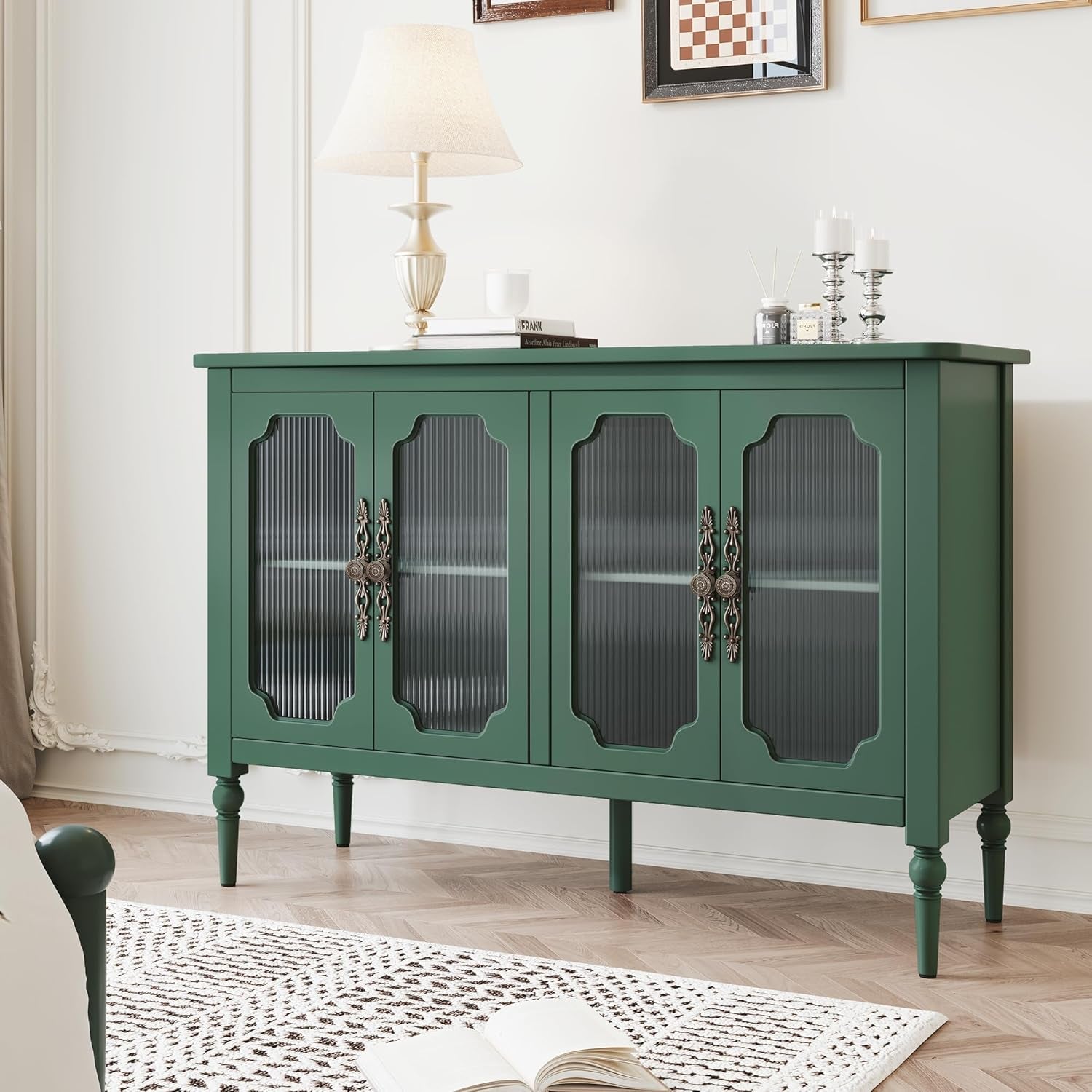 Green sideboard with glass doors in a room with a lamp and decor items.