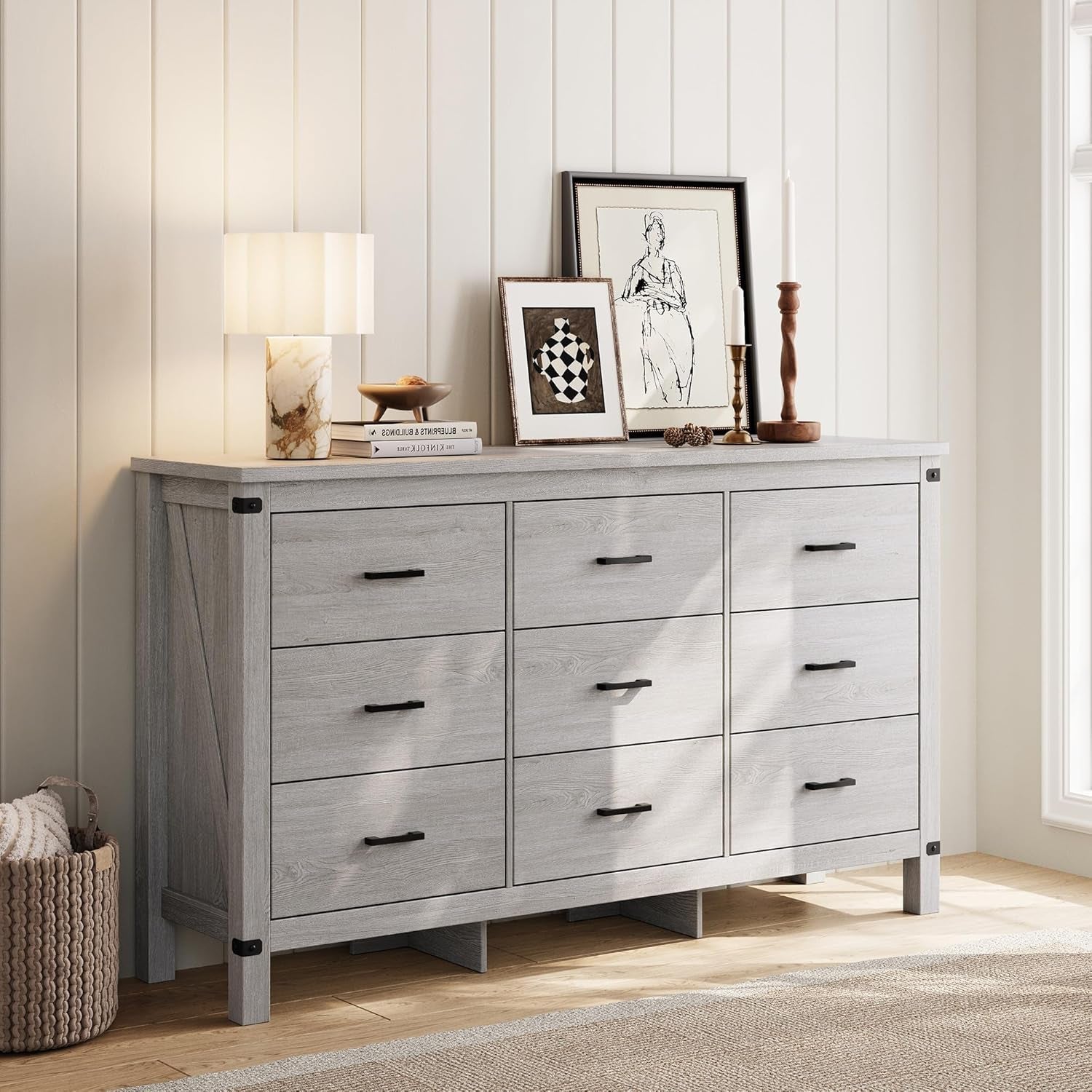 Gray dresser with decorative items in a room with wooden flooring and white walls.