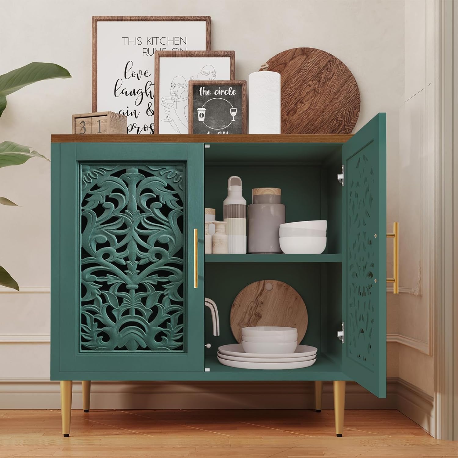 Green cabinet with decorative patterns on doors, displaying kitchen items in a room.