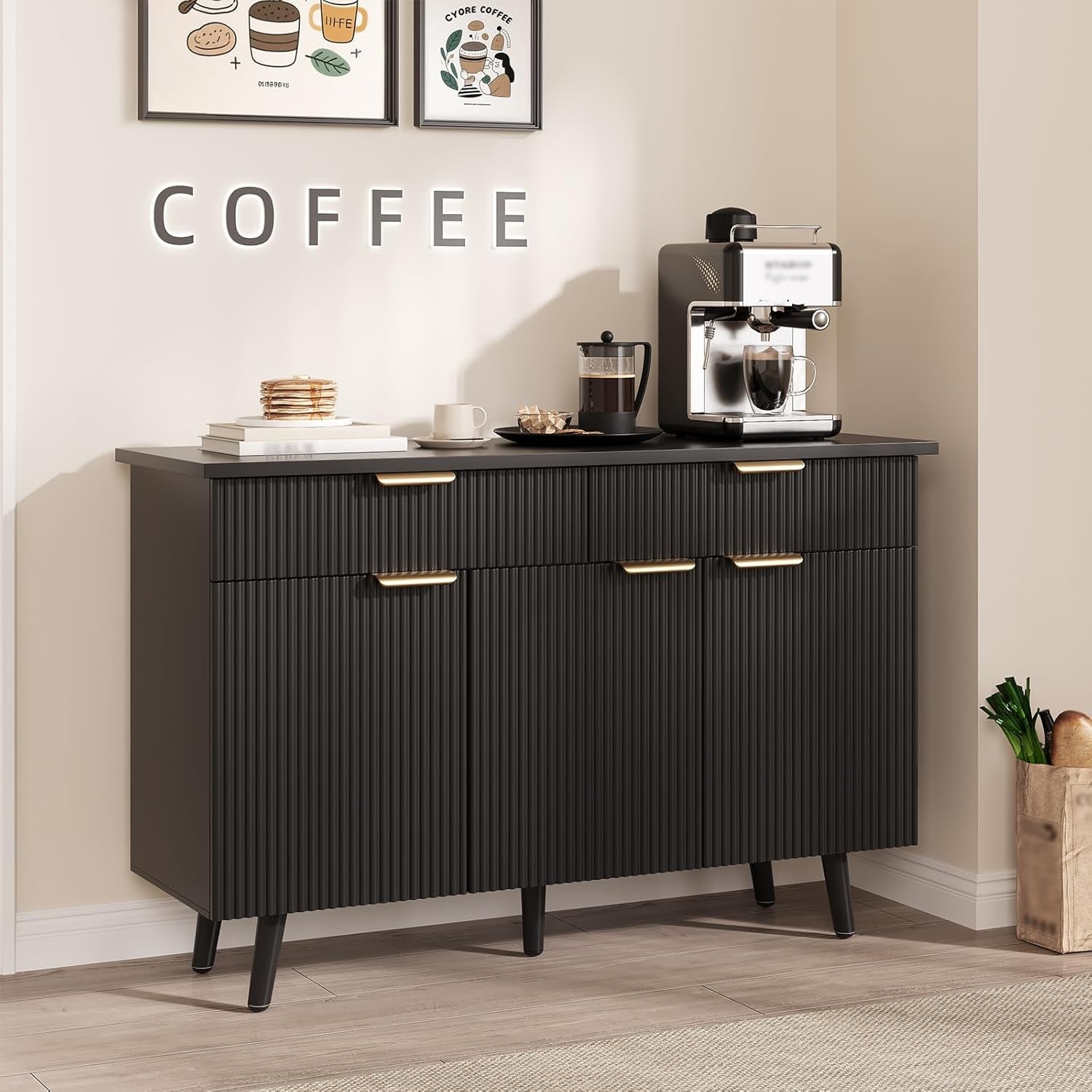 Black coffee bar cabinet with a coffee machine and decor items against a beige wall.