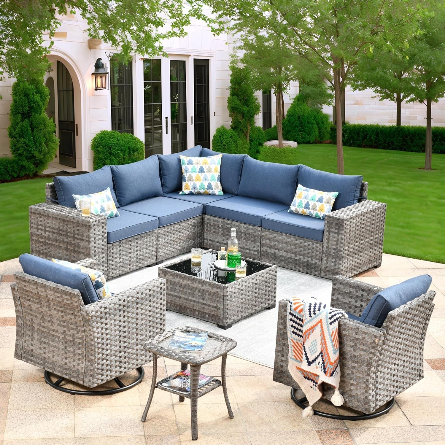 Outdoor patio furniture set with blue cushions and gray frames on a patio.