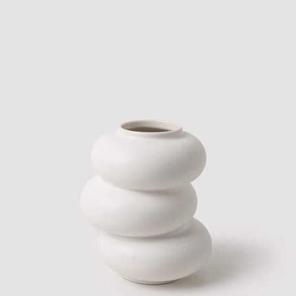 White ceramic vase with stacked design on a light gray background
