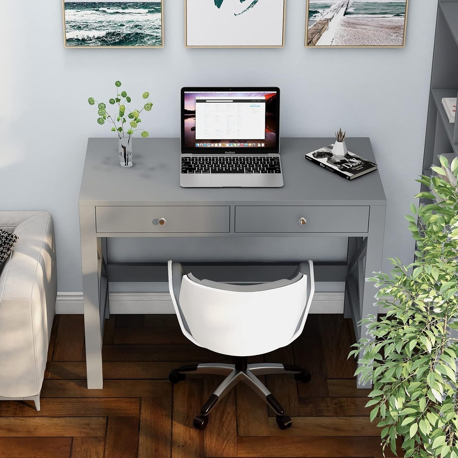 Gray desk with a laptop, white chair, and decorative items in a home office setting.