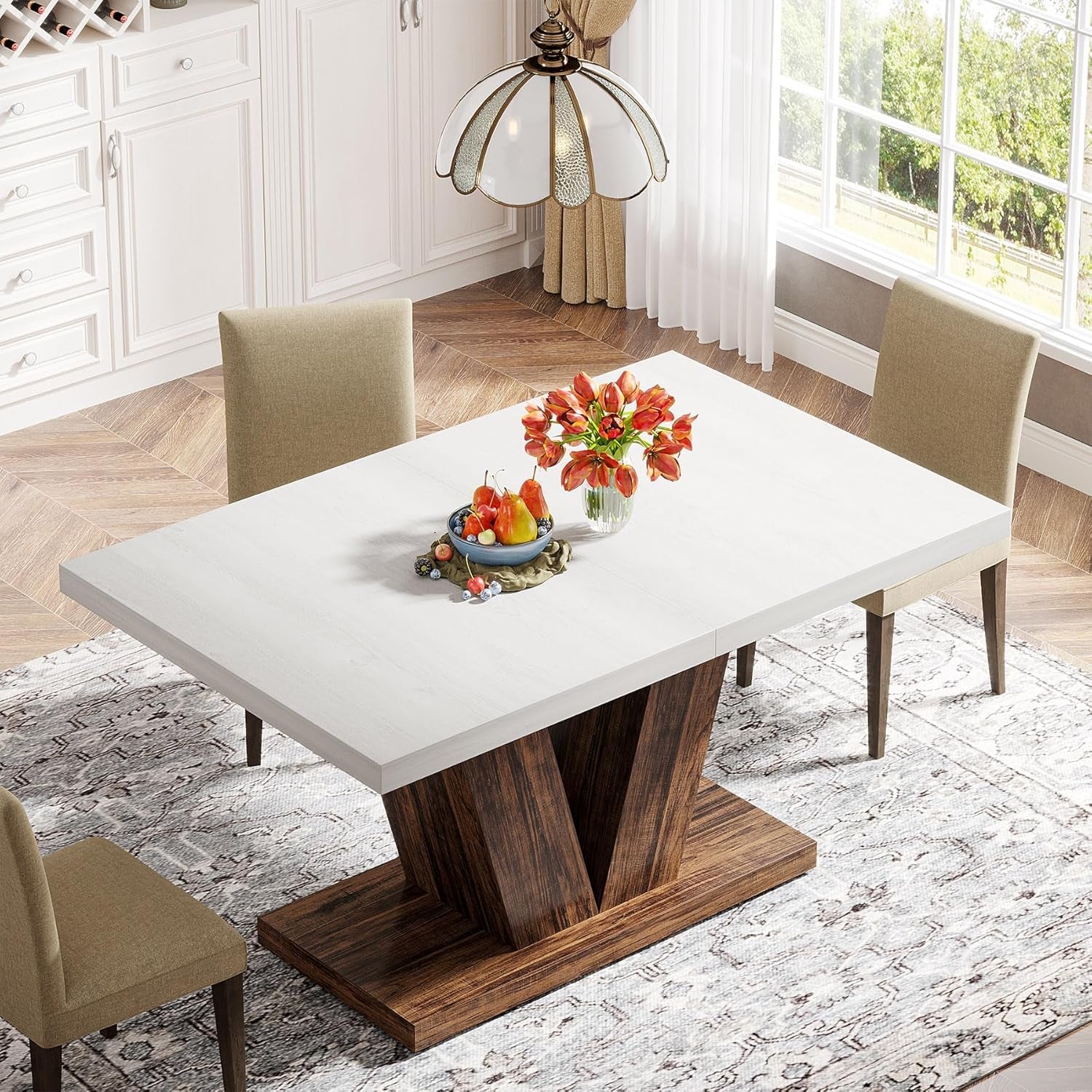 Dining table with white top and wooden base in a room with chairs and decor.