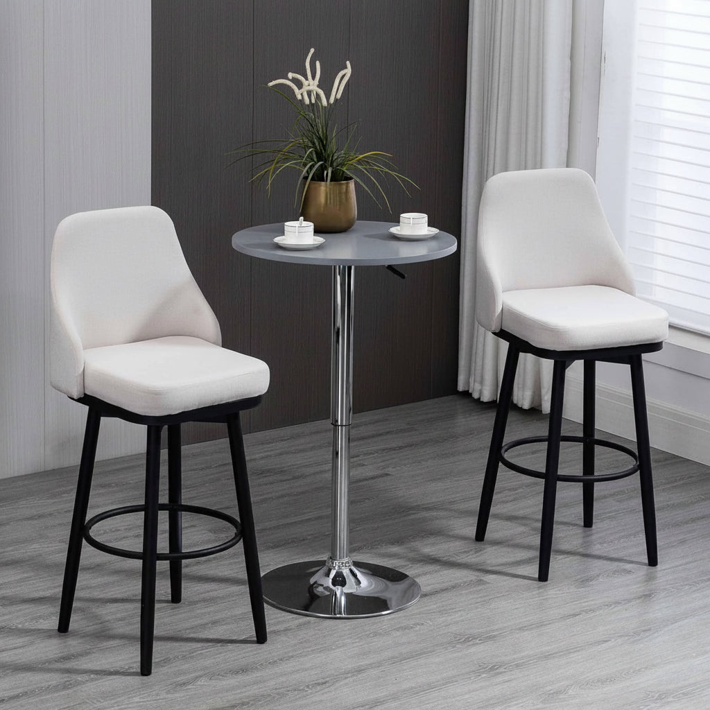 Two bar stools with white seats and black legs around a small round table in a room with a dark wall and window.