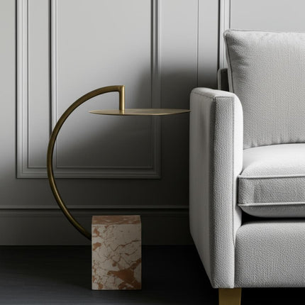 Modern interior with a gray sofa and gold side table against a gray wall.