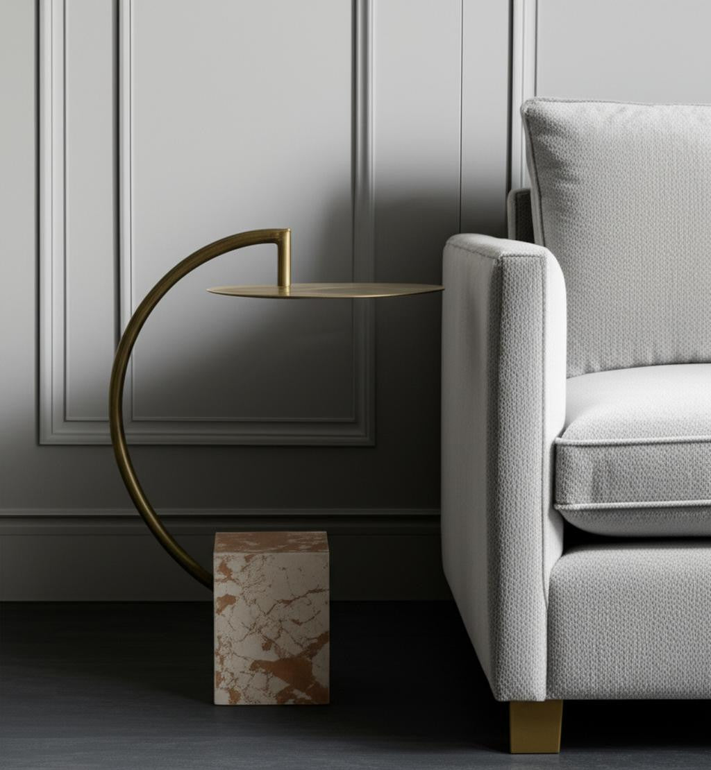 Modern interior with a gray sofa and gold side table against a gray wall.