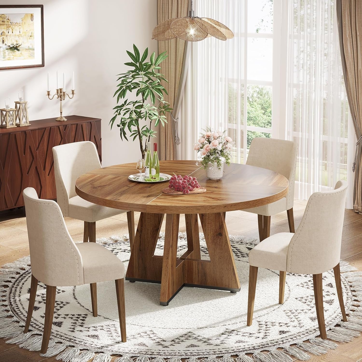 Dining room with a wooden round table and white chairs, featuring a plant and decorative items.