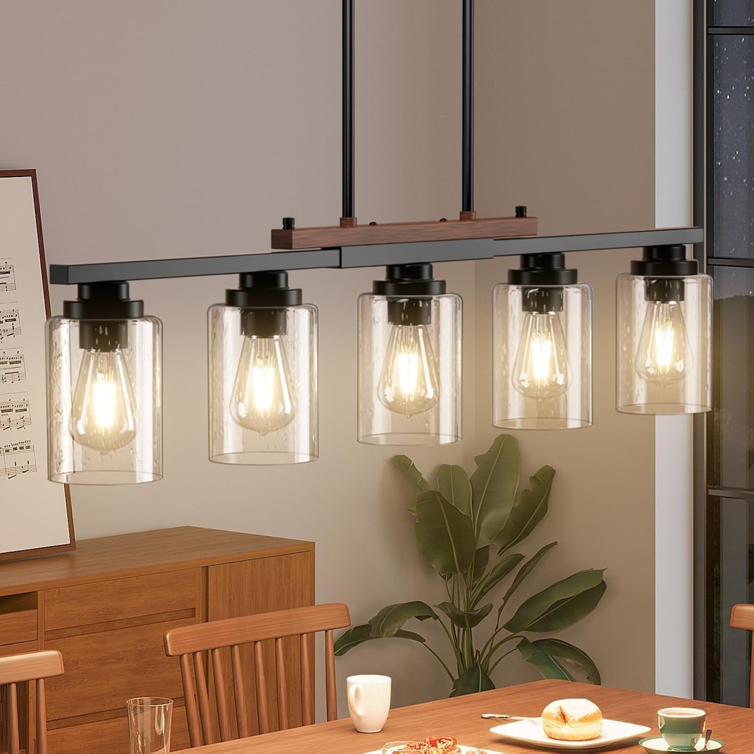 Modern pendant light fixture with glass shades in a dining room setting.