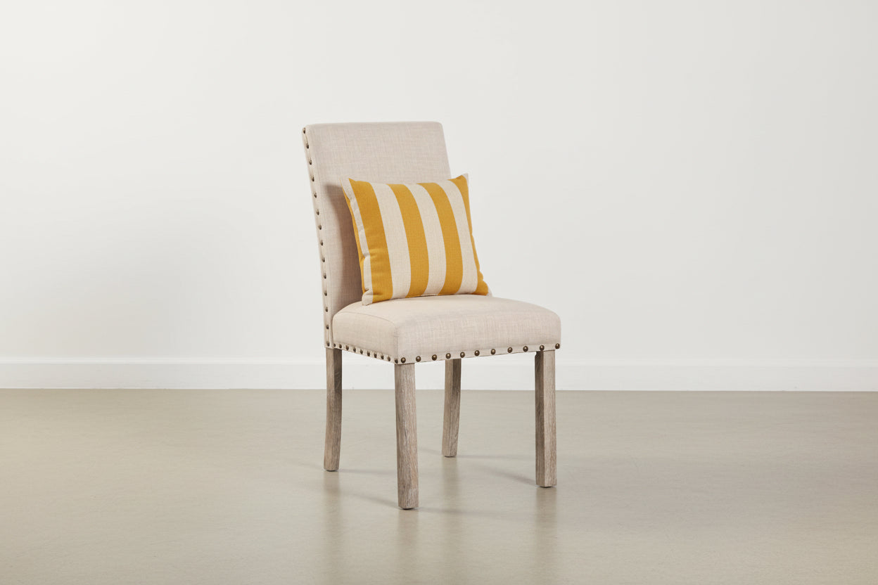 Beige chair with vintage rivets and comfy cushion, featuring ergonomic design and weight capacity information.