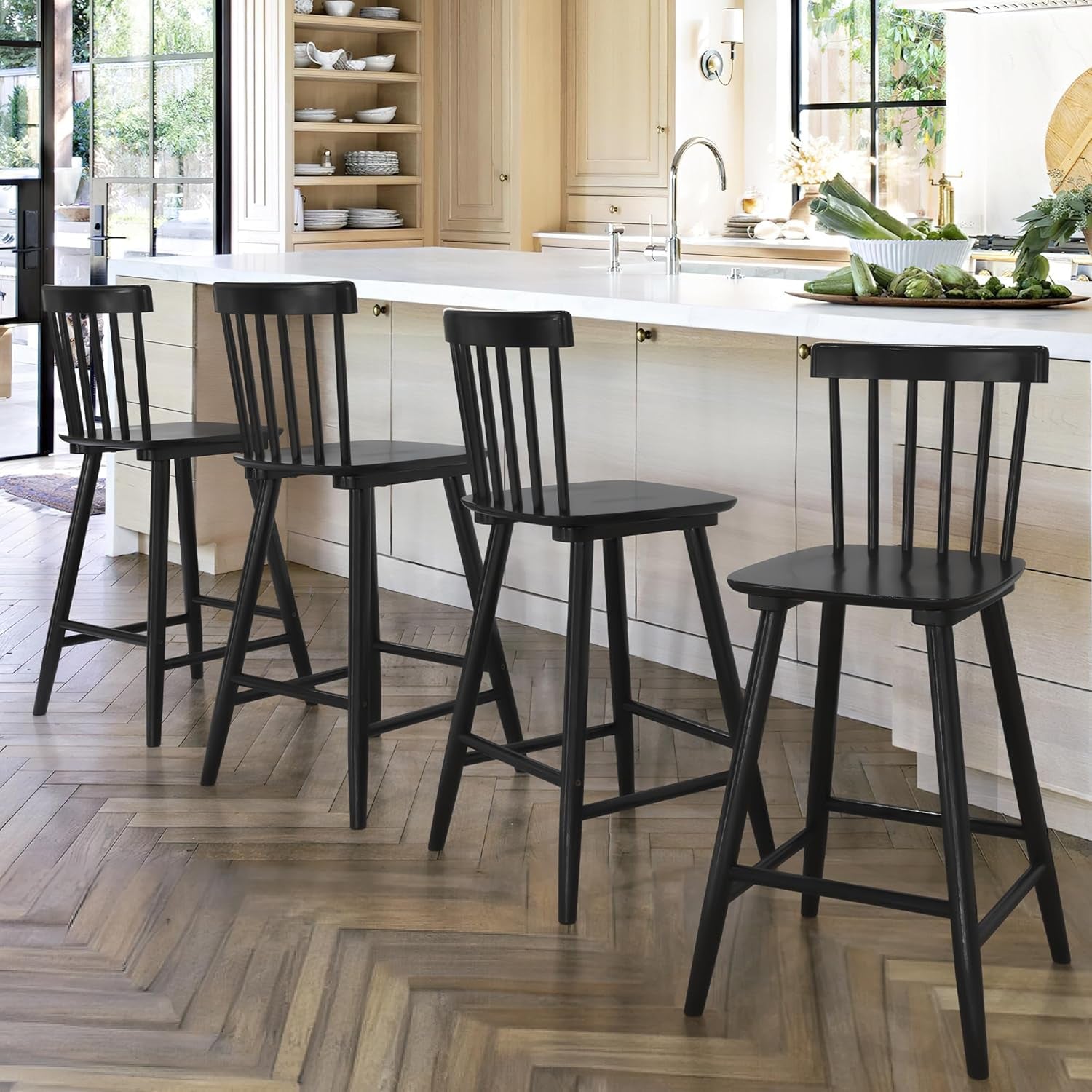 Four black bar stools in a kitchen setting with a white countertop and wooden floor.