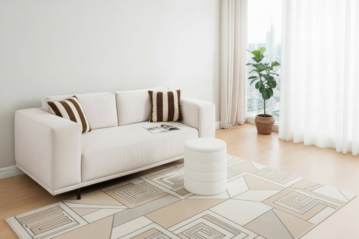 Person sitting on a white couch with a white pouf in a living room.