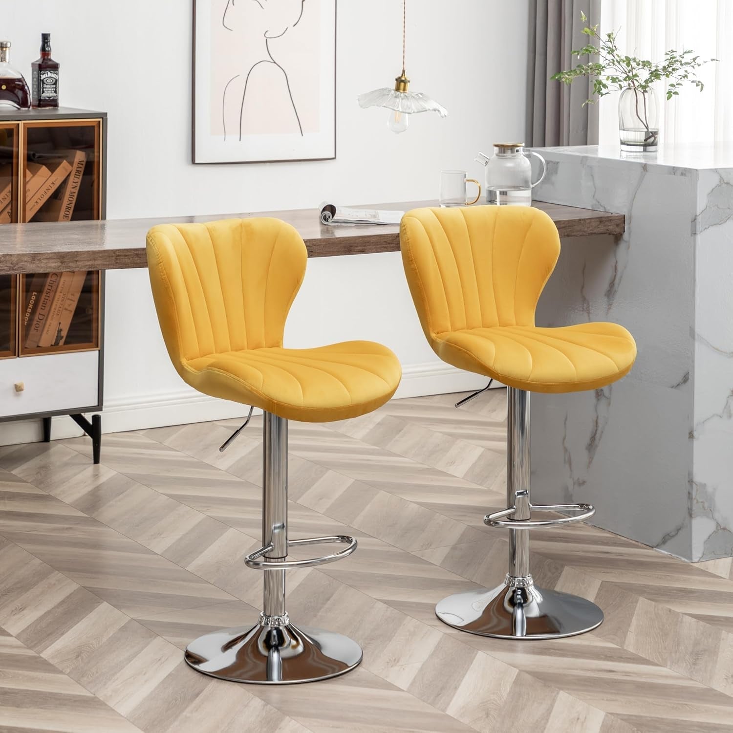 Two yellow bar stools with chrome bases in a modern kitchen setting.
