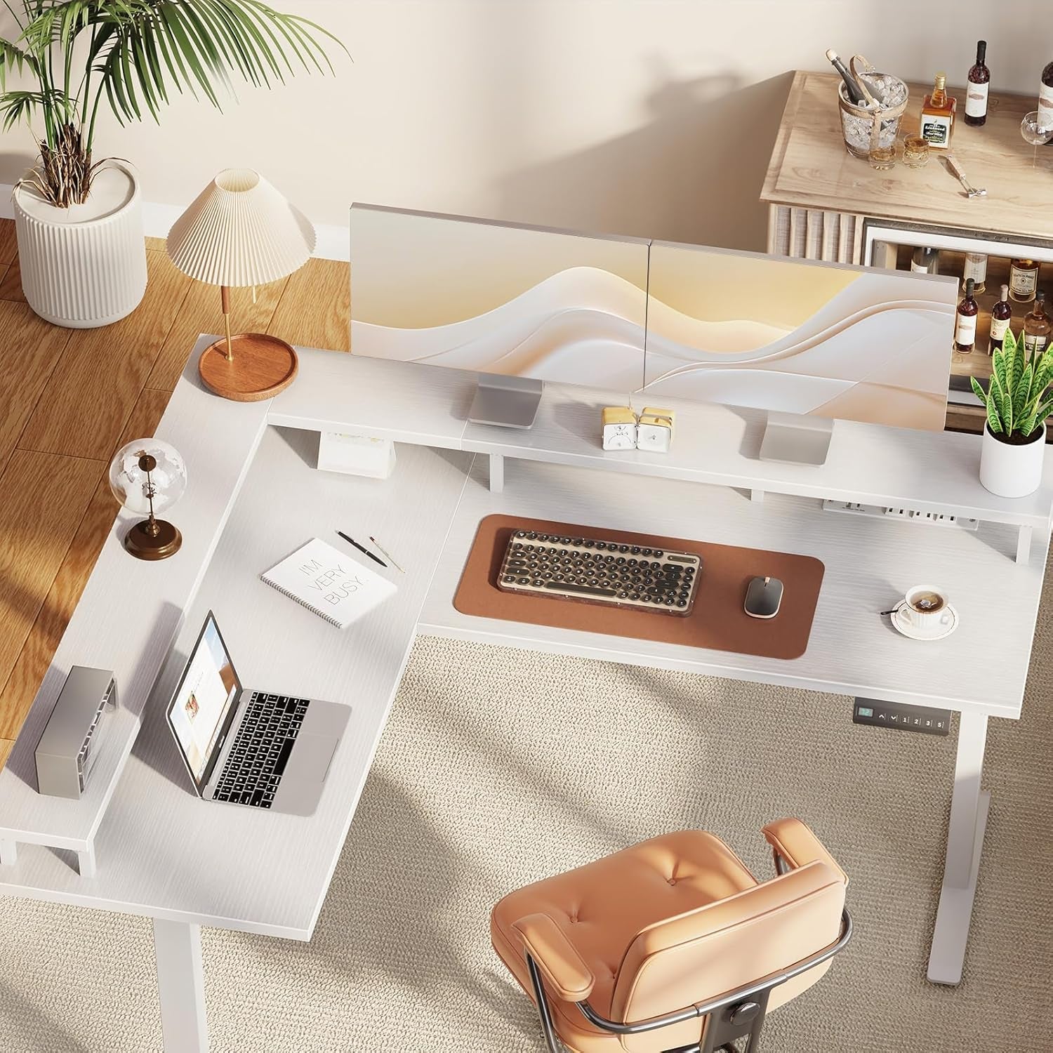 Modern office desk setup with a laptop, keyboard, and chair in a well-lit room.