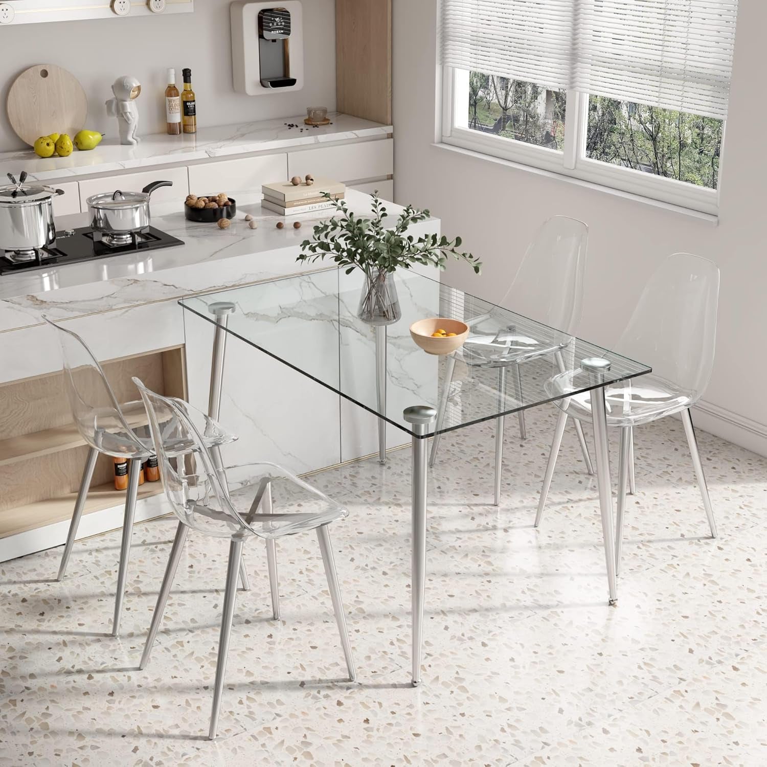 Clear glass dining table with transparent chairs in a modern kitchen.