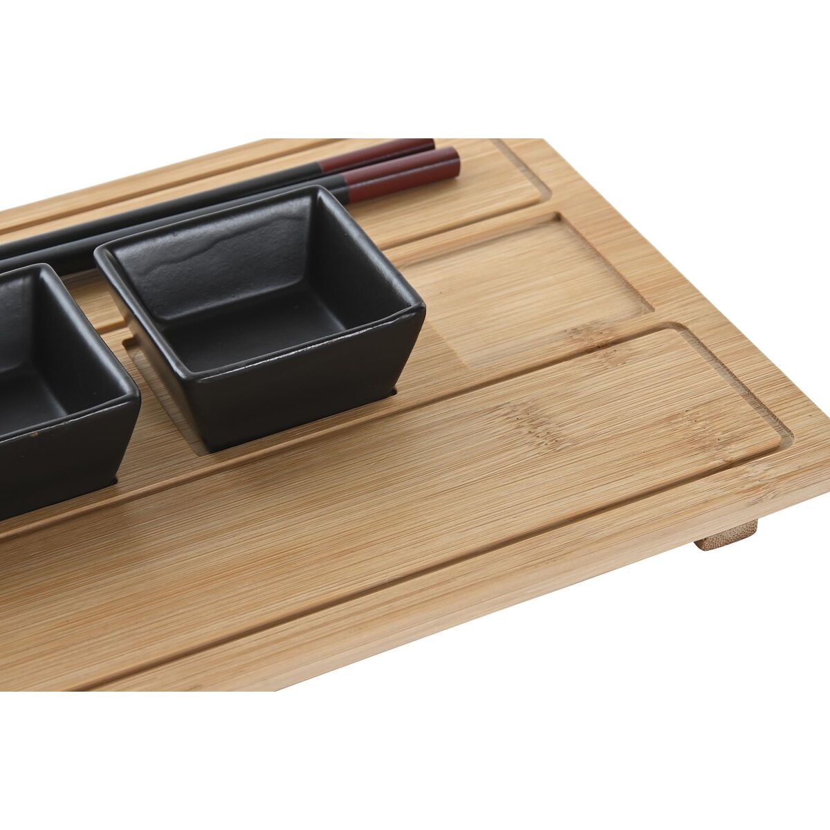 Bamboo tray with black ceramic containers and chopsticks on a white background
