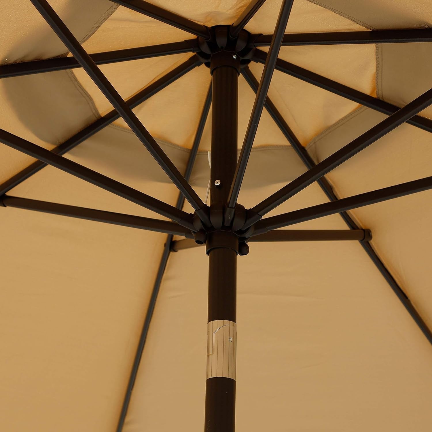 Close-up of a beige patio umbrella with a black frame.