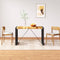 Dining table with two chairs in a room with a framed picture on the wall.