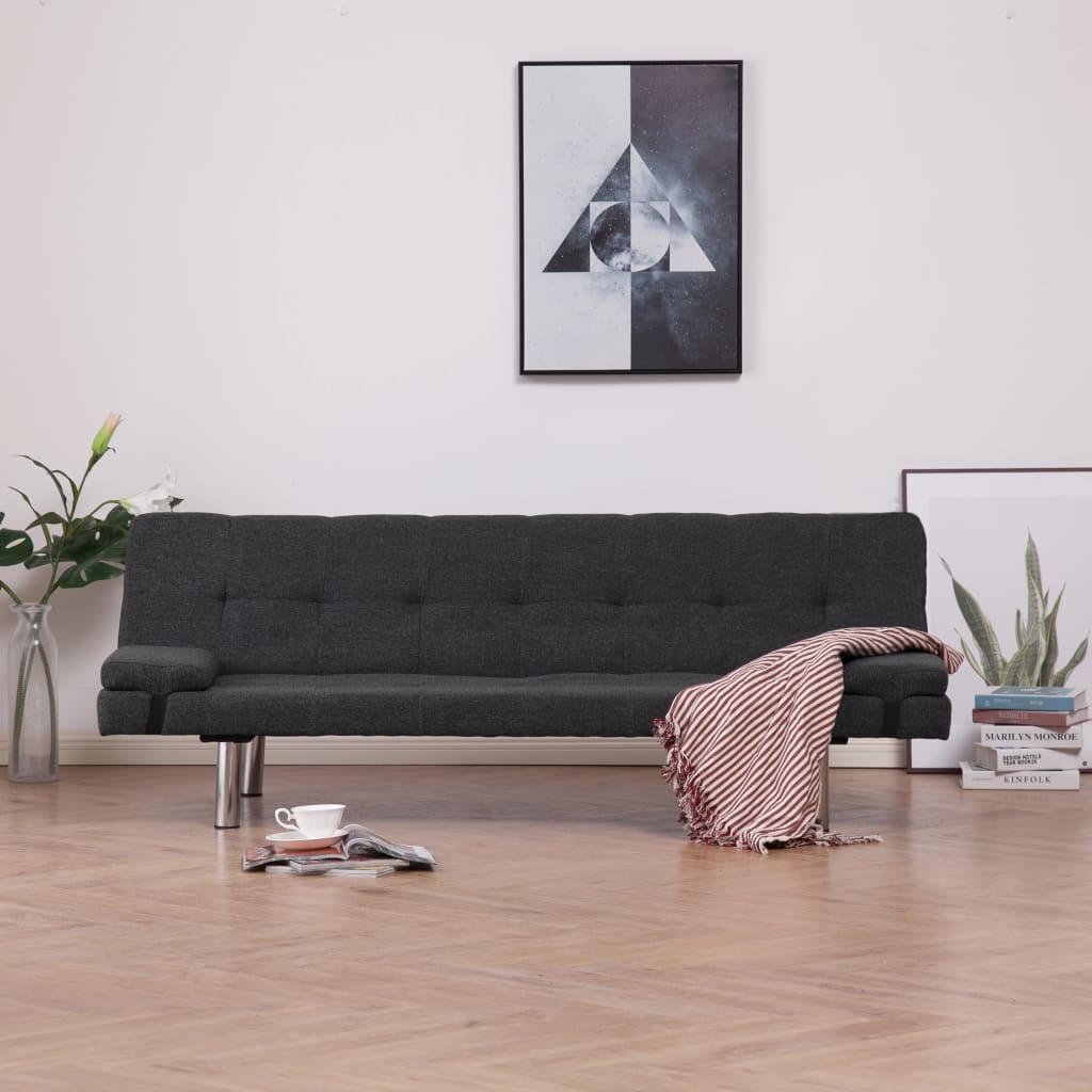 Modern living room with a black sofa, coffee table, and decorative items.