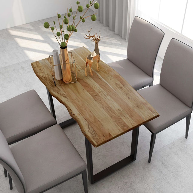 Dining table with natural wood finish and decorative items, surrounded by gray chairs in a bright room.