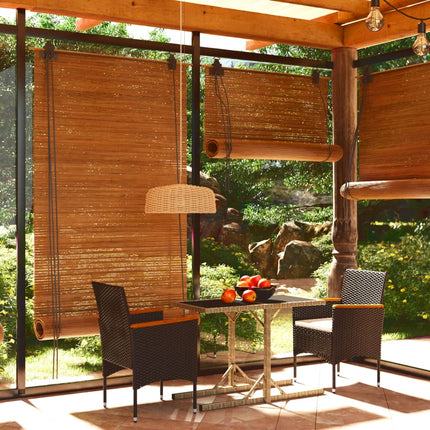 Dining area with wooden table and chairs under a wooden pergola with bamboo shades.