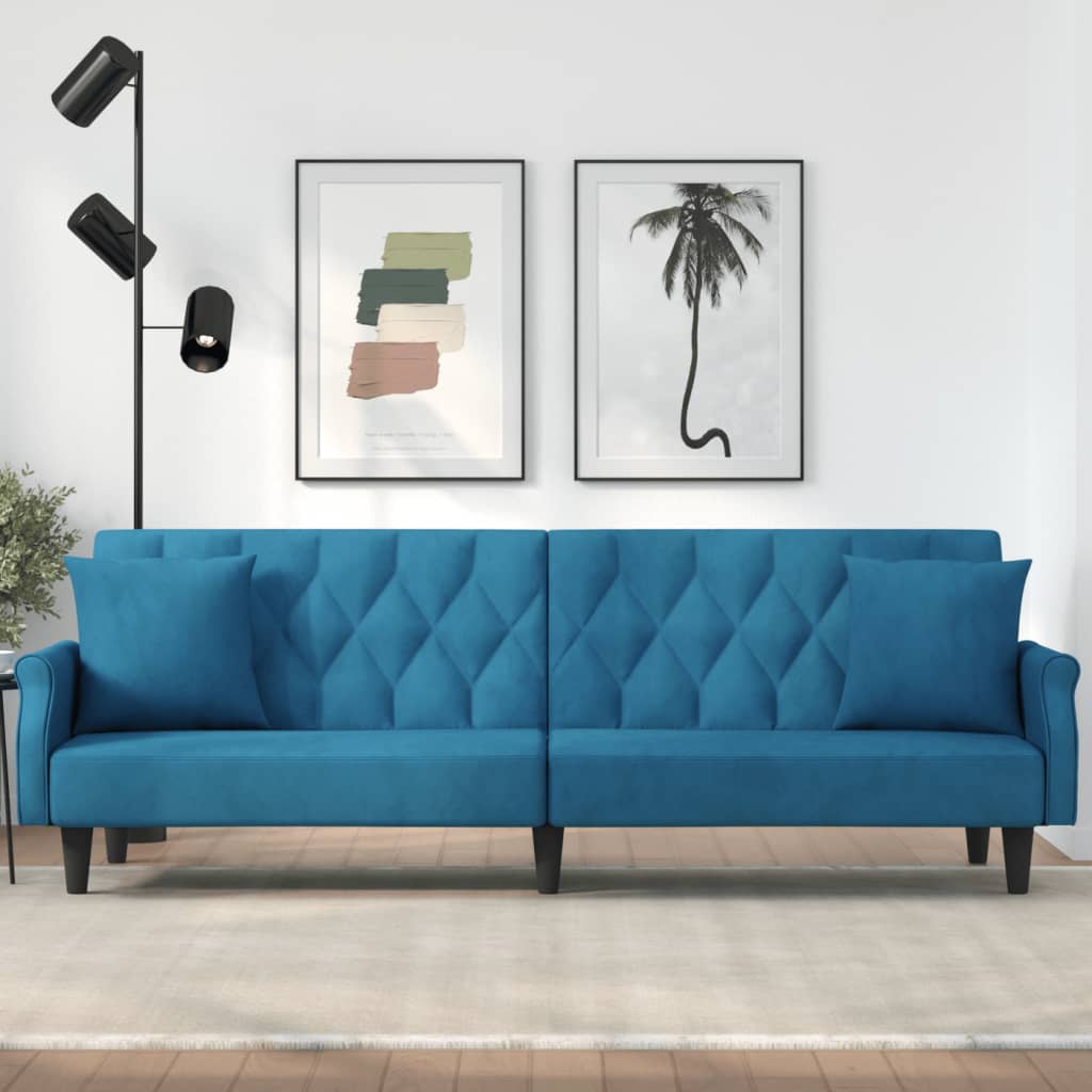 Blue sofa in a room with wall art and a lamp.