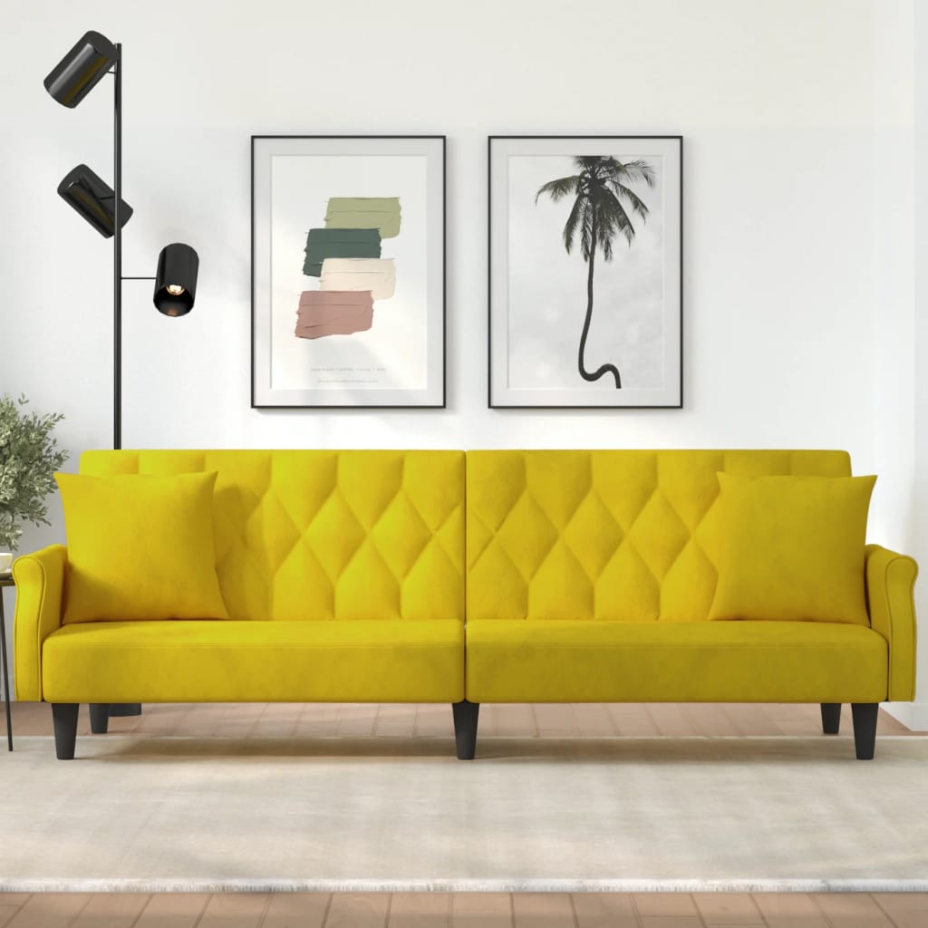 Yellow sofa in a room with framed artwork on the wall.