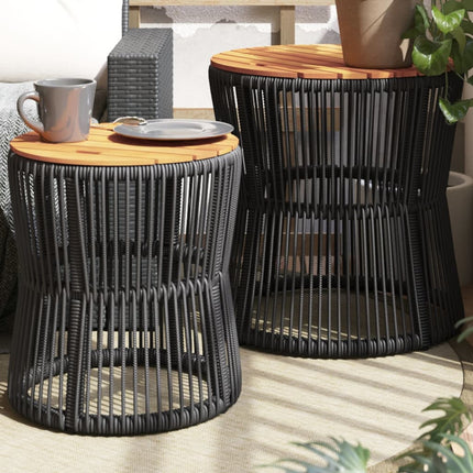 Two black woven side tables with wooden tops on a patio.
