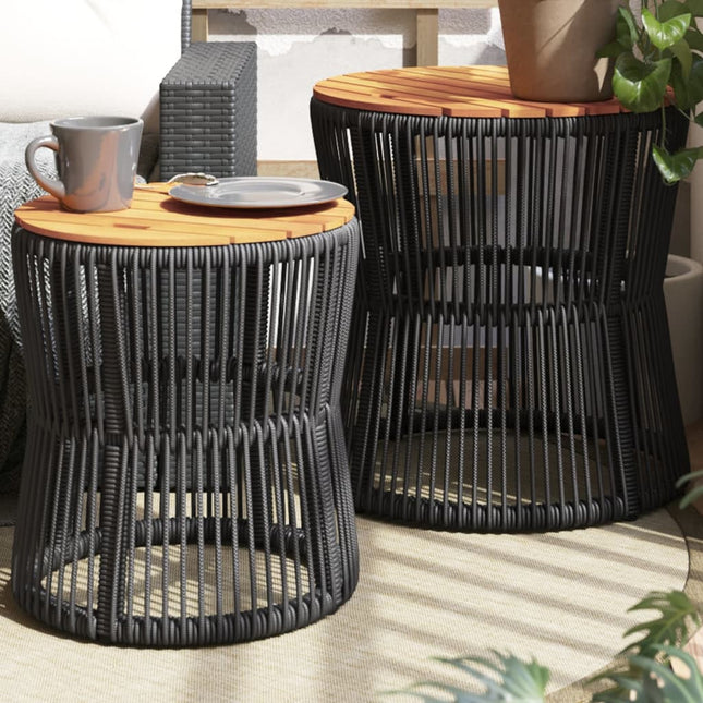 Two black woven side tables with wooden tops on a patio.