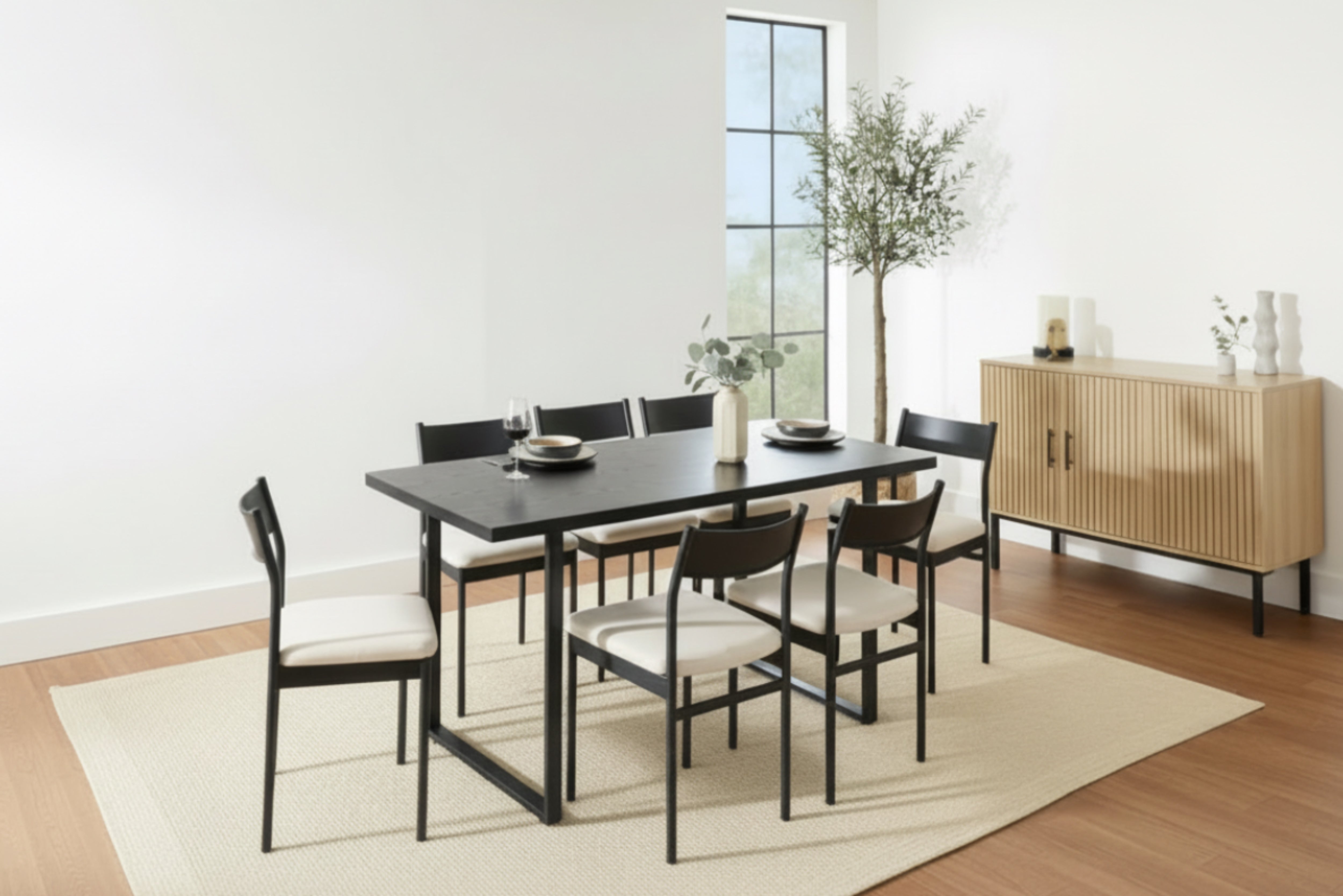 Group of people sitting around a dining table in a modern living room.