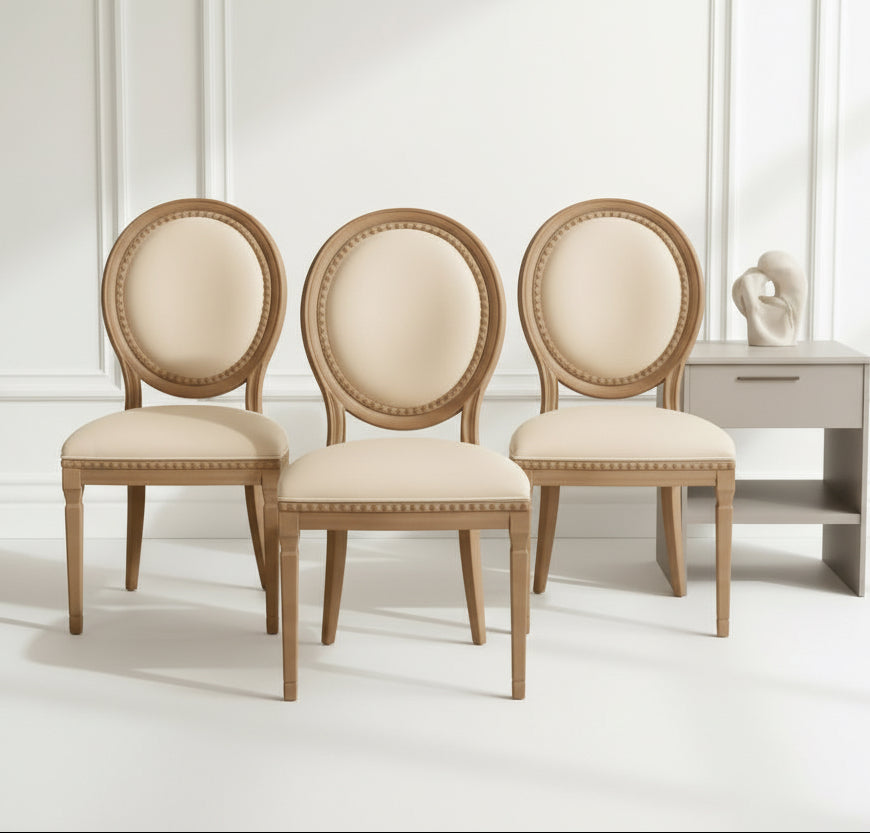 Three beige chairs with white cushions in a room with a green wall and a small table.
