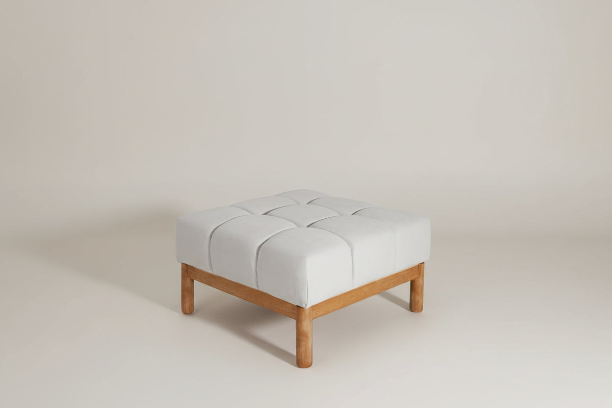 Gray cushioned ottoman with wooden legs on a white background