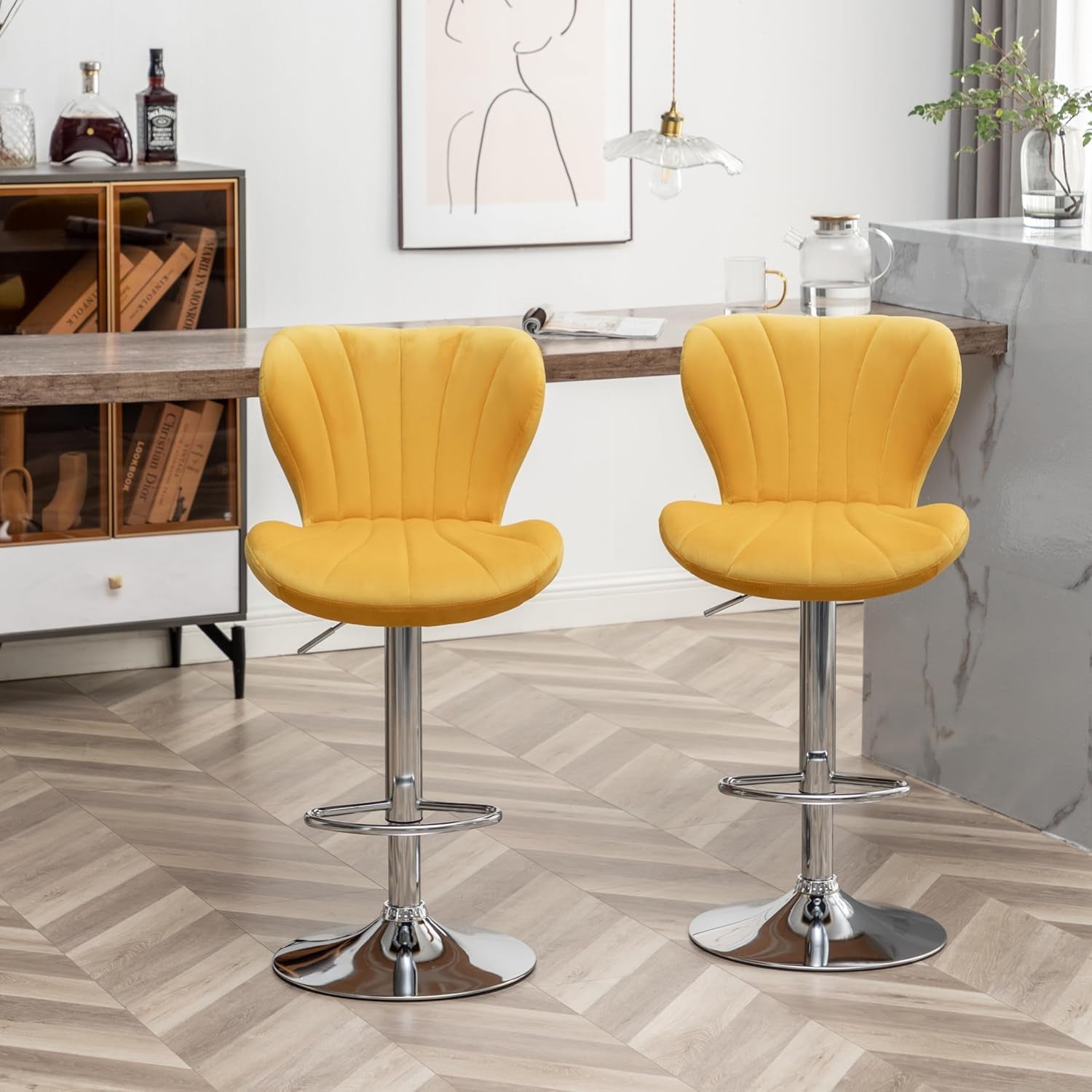 Two yellow bar stools with chrome bases in a modern kitchen setting.