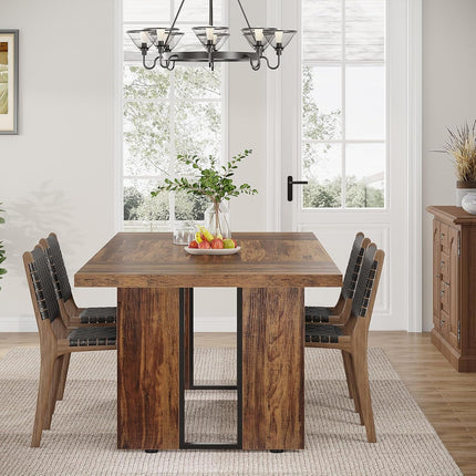 Dining room with wooden table and chairs, fruit on the table, and a chandelier.
