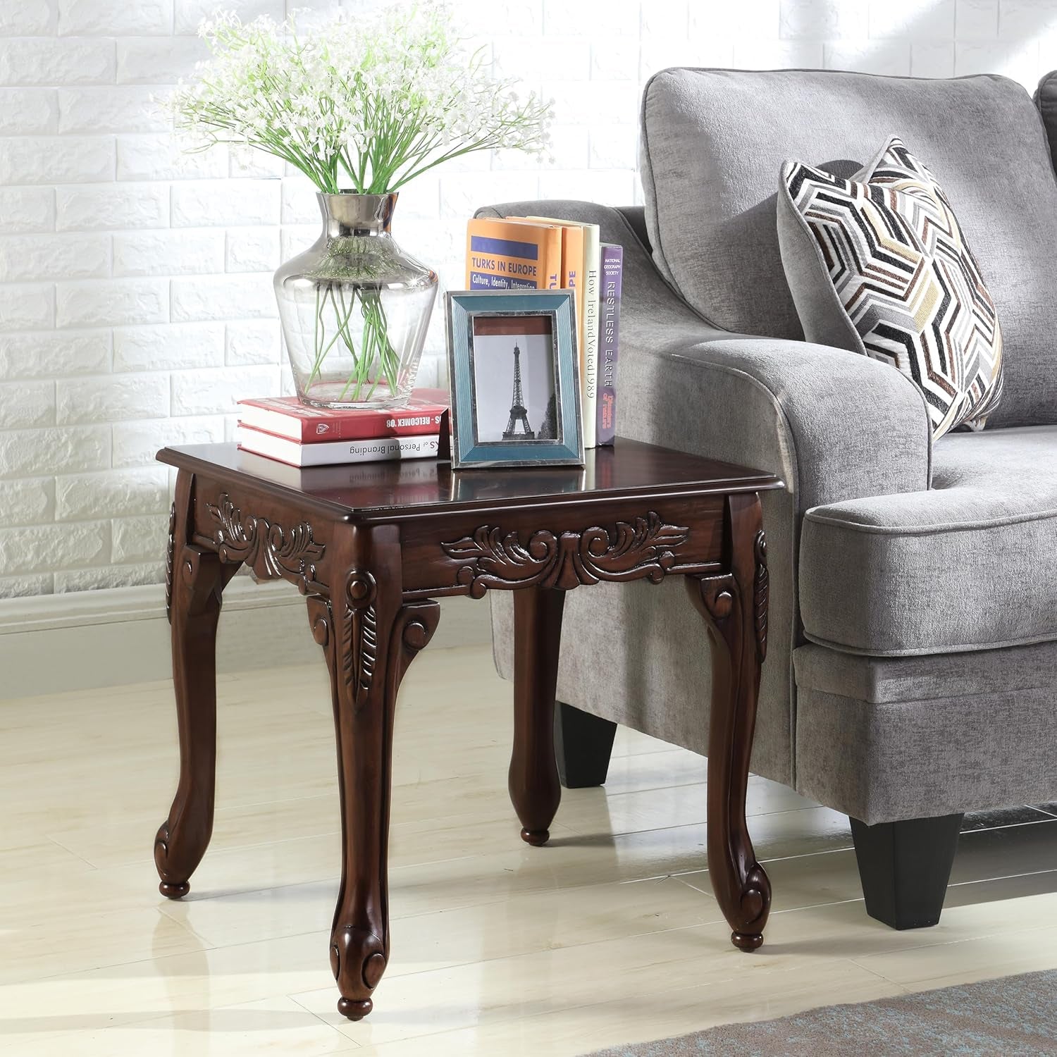 Wooden side table with decorative items next to a gray sofa.