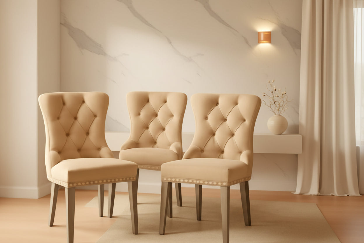 Three beige upholstered chairs in a room with warm lighting.