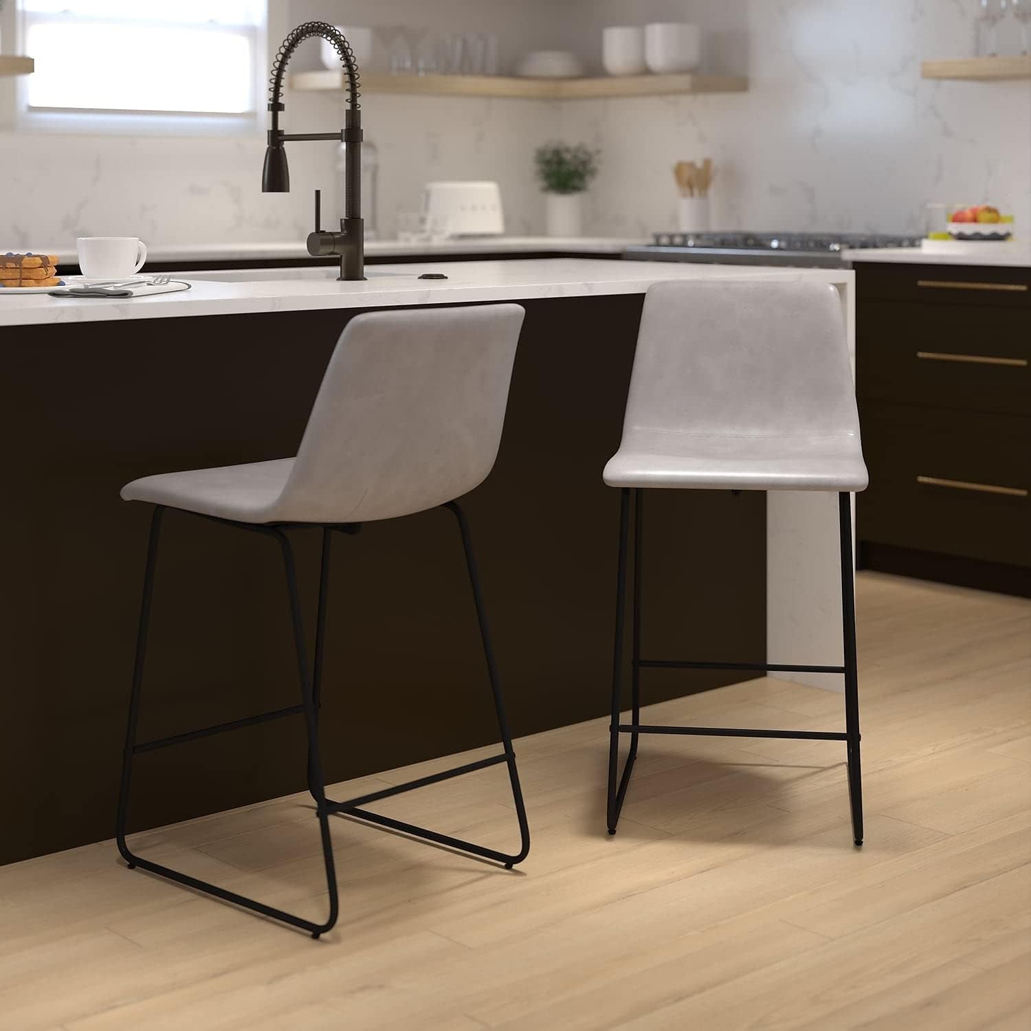 Two gray bar stools with black legs in a modern kitchen.