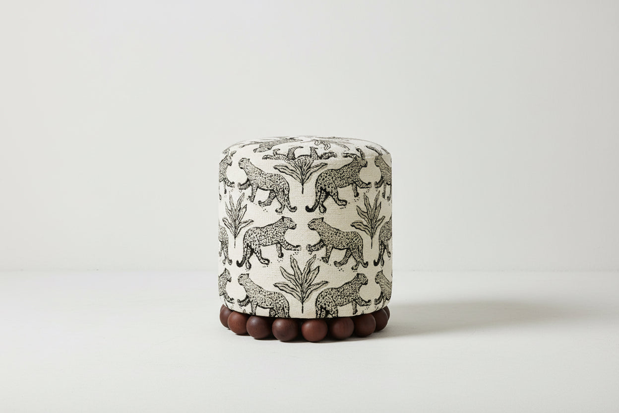 Round ottoman with leopard print design on a white background