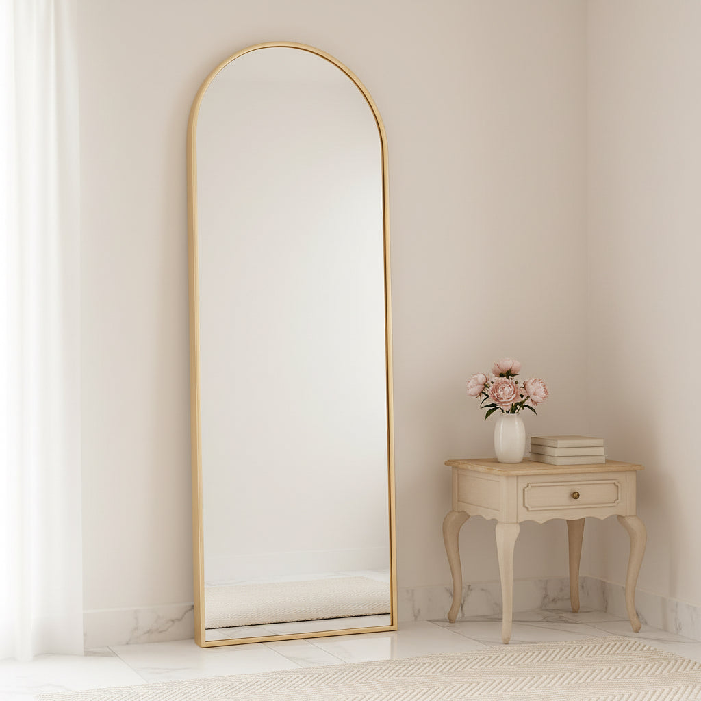 Full-length mirror against a beige wall with a side table and lamp in the corner.