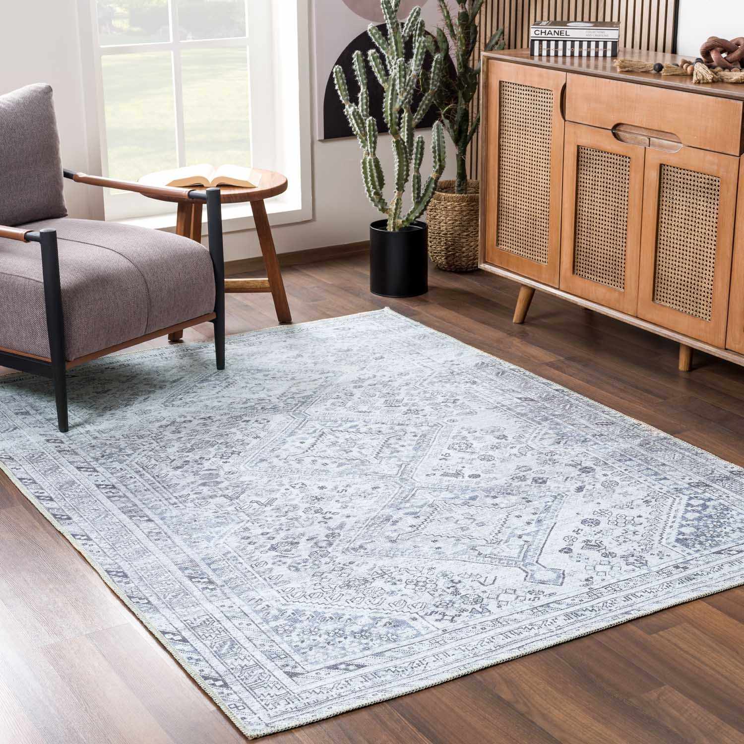 Living room with a patterned rug, chair, and wooden cabinet.
