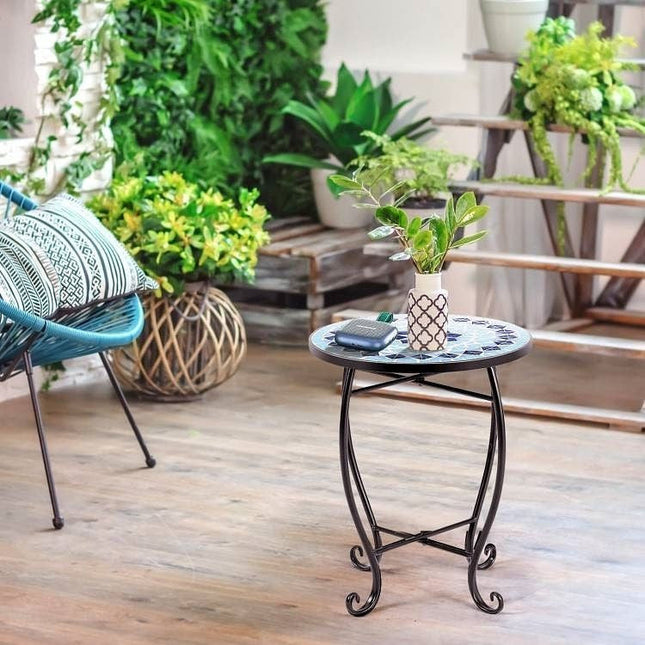 Small round table with decorative items in a room with plants and furniture.